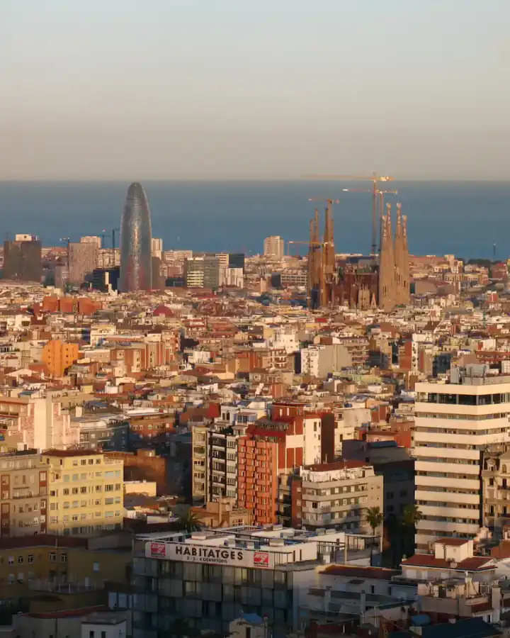 Barcelona al capvespre des del parc del Putxet, amb la Sagrada Família i la torre Glòries davant del mar