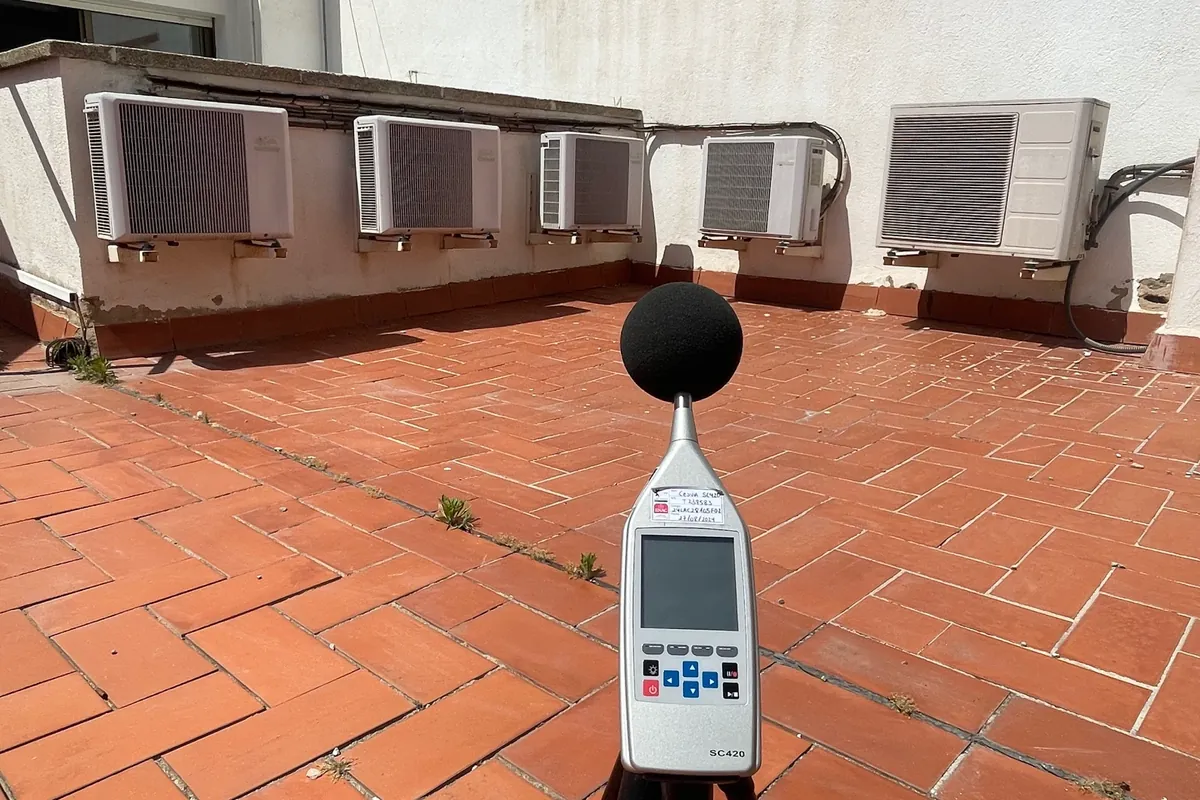 Sonòmetre sobre un trípode en un terrat mesurant el soroll d’unes instal·lacions de climatització